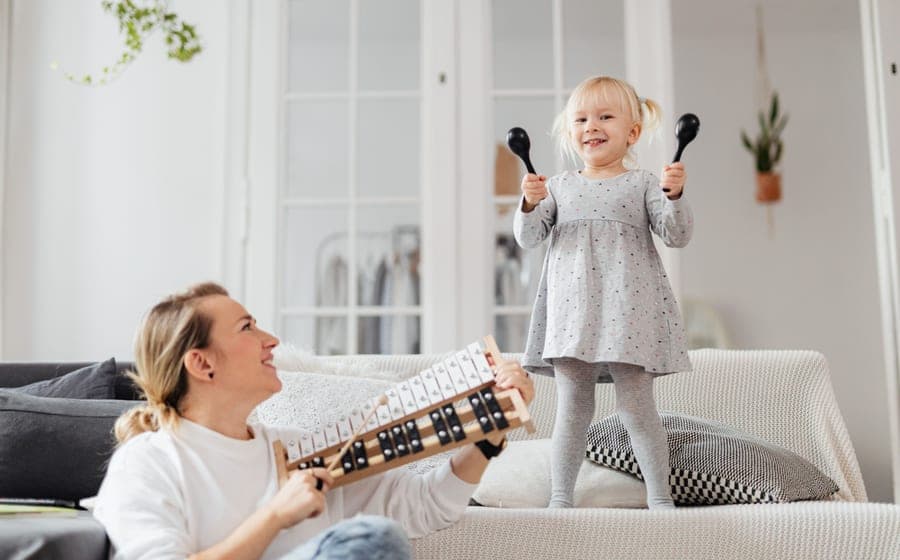 An adult and a child with a musical instrument at home