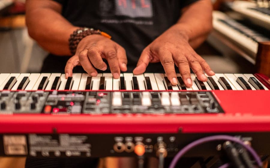 A person playing a portable electronic keyboard at home